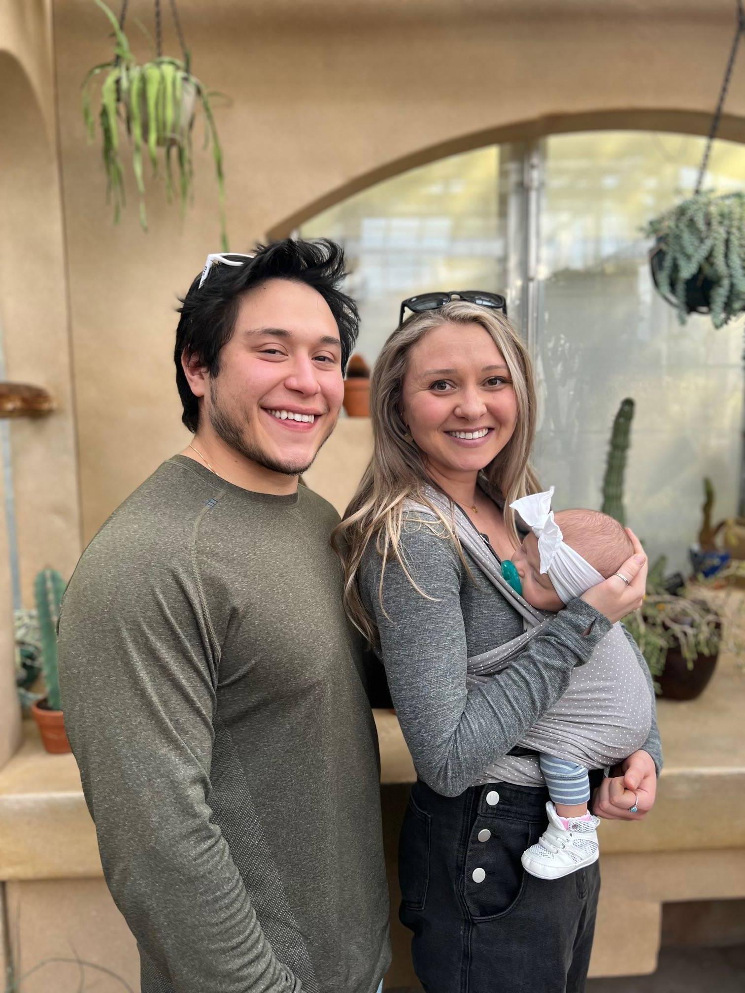 Douglas Ayers smiling with his wife Danielle as they hold their new baby girl, Aria